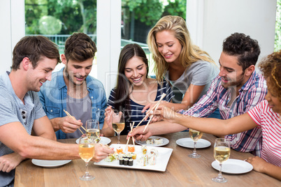 Friends enjoying wine and sushi at home