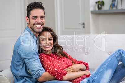 Portrait of romantic couple hugging on sofa