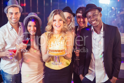 Happy friends celebrating birthday with cake