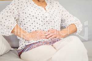 Midsection of senior woman suffering from stomach pain