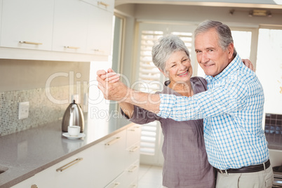 Portrait of cheerful senior man dancing with wife