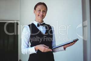 Smiling waitress holding a menu