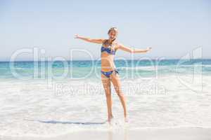 Carefree woman in bikini standing on the beach