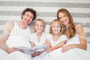 Portrait of smiling family on bed