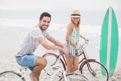 Happy couple with their bicycle on the beach