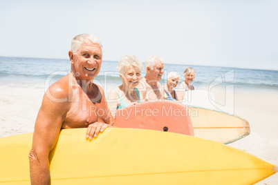 Senior friends holding surfboard