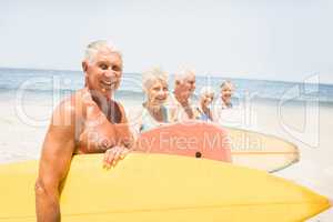 Senior friends holding surfboard