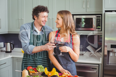 Happy couple toasting wine in kitchen