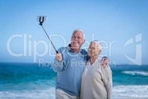 Cute mature couple taking selfie with selfie stick