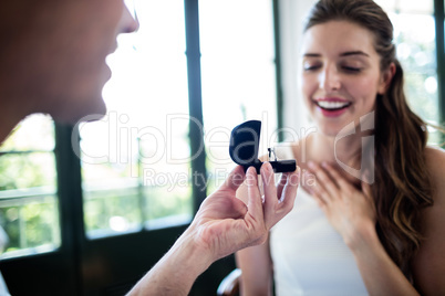 Man proposing to woman offering engagement ring