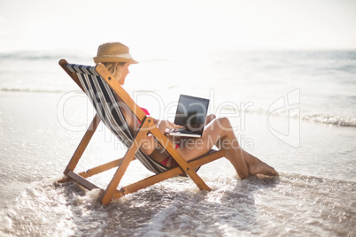 Woman sitting on a armchair and using a laptop