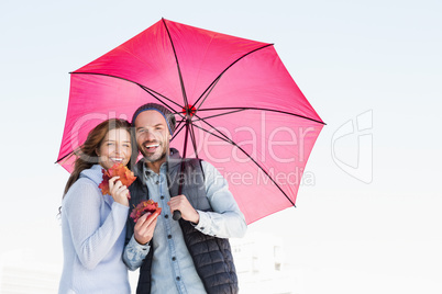 Happy young couple holding umbrella