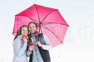 Happy young couple holding umbrella