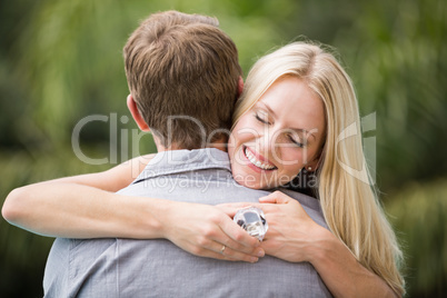 Smiling young woman with eyes closed while hugging man
