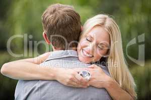 Smiling young woman with eyes closed while hugging man