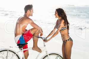 Couple going on a bike ride on the beach
