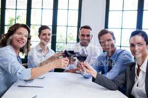 Portrait of businesspeople toasting wine glass during business l