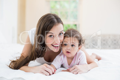 Happy mother lying with baby at home