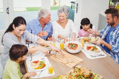 Smiling multi generation family having food