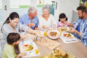 Smiling multi generation family having food