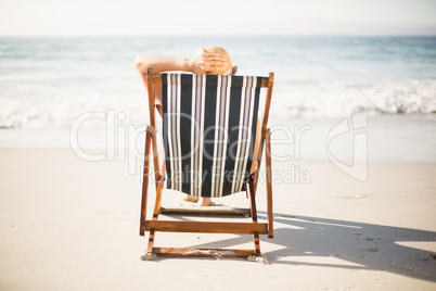 Rear view of woman relaxing on the beach