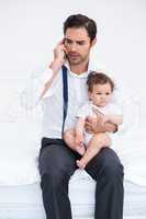 Father talking on mobile phone with baby