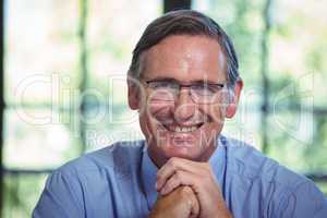 Smiling businessman leaning on a table