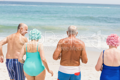 Senior friends going into water