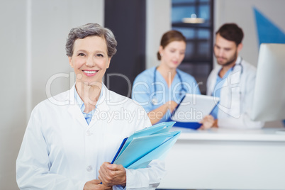 Portrait of smiling female doctor holding medical reports
