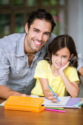 Portrait of smiling father and daughter studying