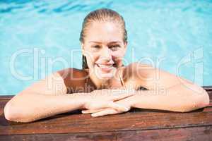 Portrait of beautiful woman leaning on poolside