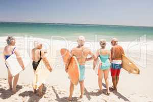 Senior friends holding surfboard