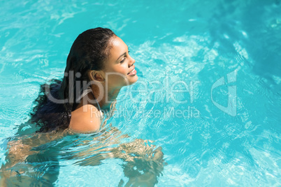 Beautiful woman in white bikini swimming in swimming pool