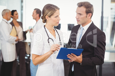 Doctors discussing the report on clipboard