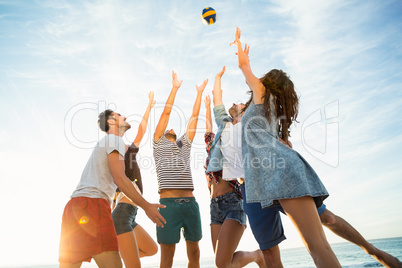 Friends trying to catch volley ball