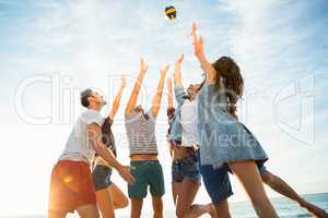 Friends trying to catch volley ball