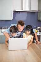 Father and children using laptop