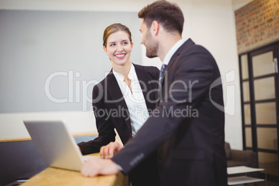 Business people talking while standing by counter