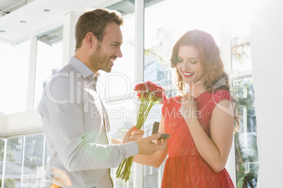 Man offering flowers and engagement ring