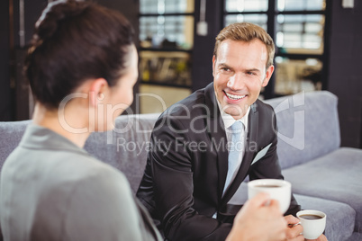 Businessman and businesswoman having tea during breaktime