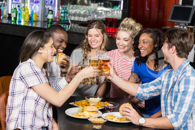 Happy friends having a drink and hamburger