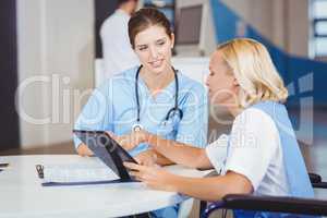 Female doctors using digital tablet while discussing