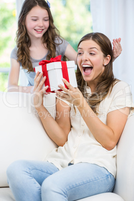 Woman surprised looking at gift given by daughter