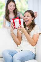 Woman surprised looking at gift given by daughter