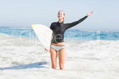 Woman with surfboard standing in sea