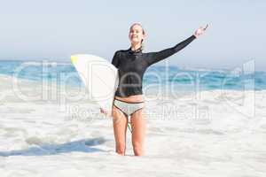 Woman with surfboard standing in sea