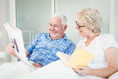 Happy senior couple reading newspaper Happy senior couple reading newspaper