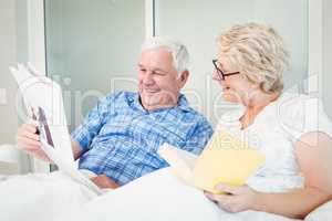 Happy senior couple reading newspaper