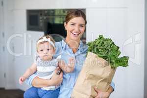 Happy woman carrying vegetables and daughter