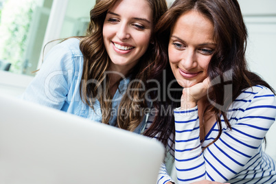 Happy female friends working on laptop